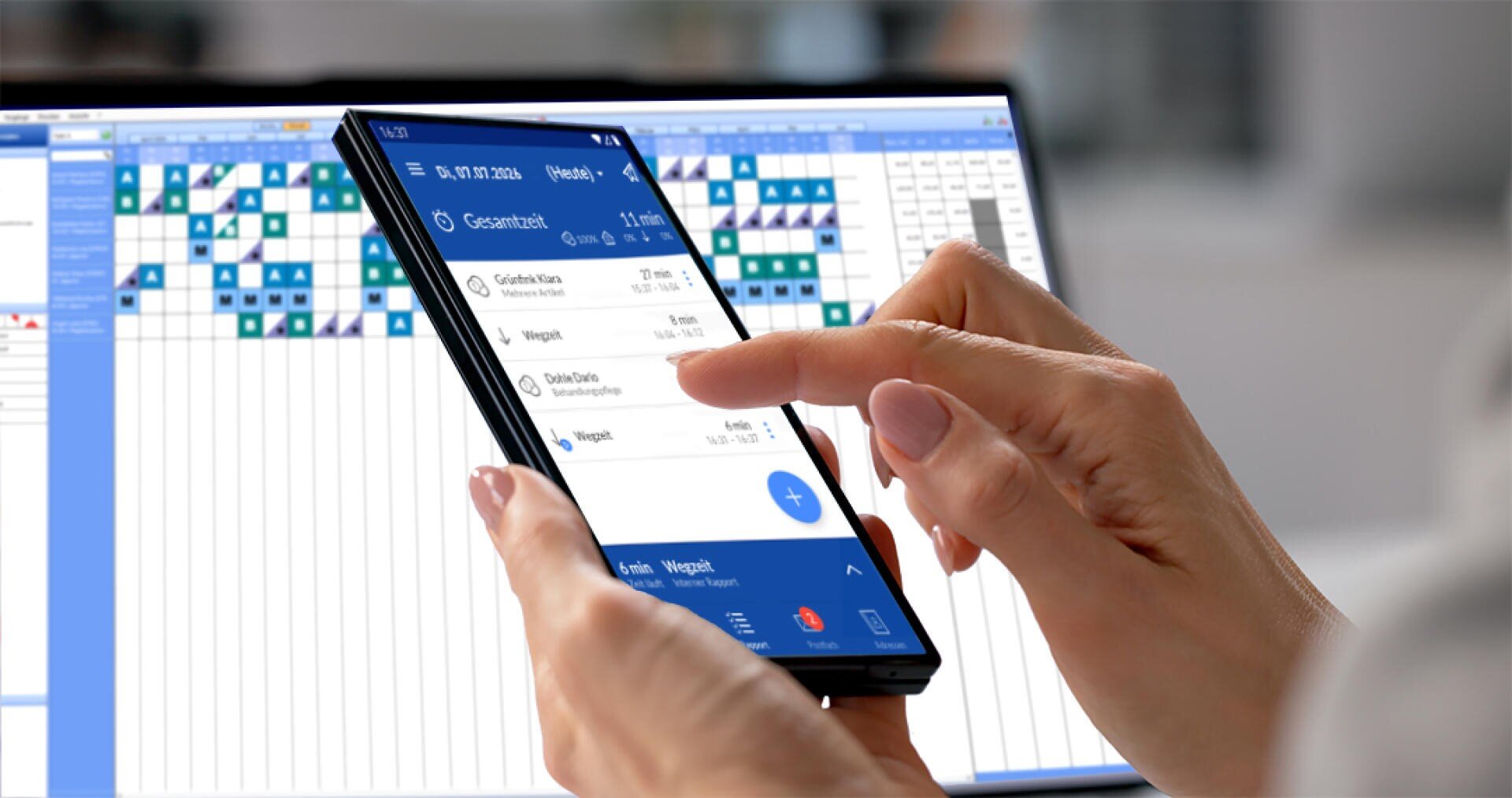 Eine Person nutzt ein Smartphone, auf dem eine Terminplanungs- oder Kalender-App angezeigt wird, während im Hintergrund auf einem Computer ein Bildschirm mit einem Raster oder einem Stundenplan zu sehen ist, was auf Multitasking oder Arbeitsplanung hindeutet.