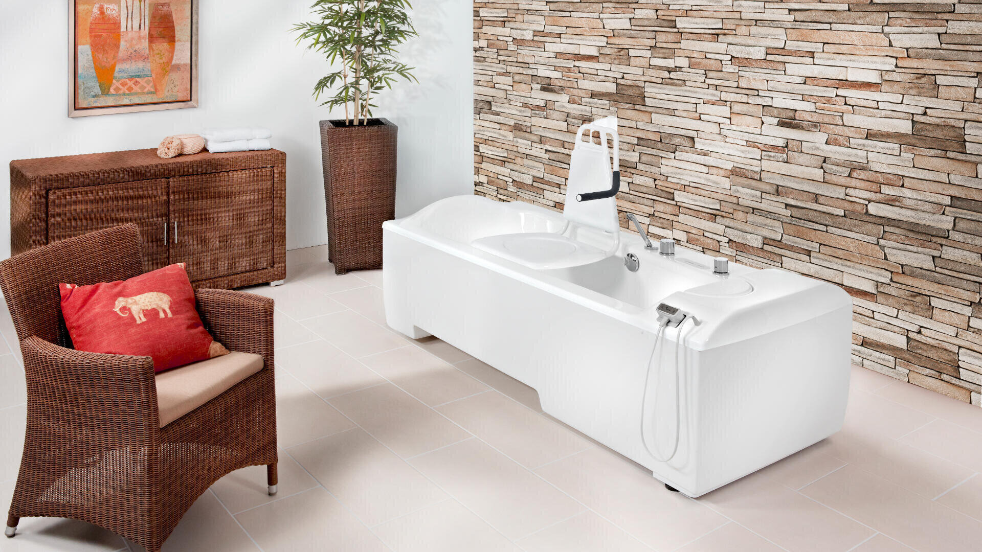 Modernes Badezimmer mit einer weißen Pflegebadewanne, die angehoben werden kann, einem Korbstuhl mit rotem Kissen, einem Holzschrank, einer hohen Pflanze und einer Akzentwand aus Stein. Fliesenboden und farbenfrohe Wandbilder runden den Raum ab.