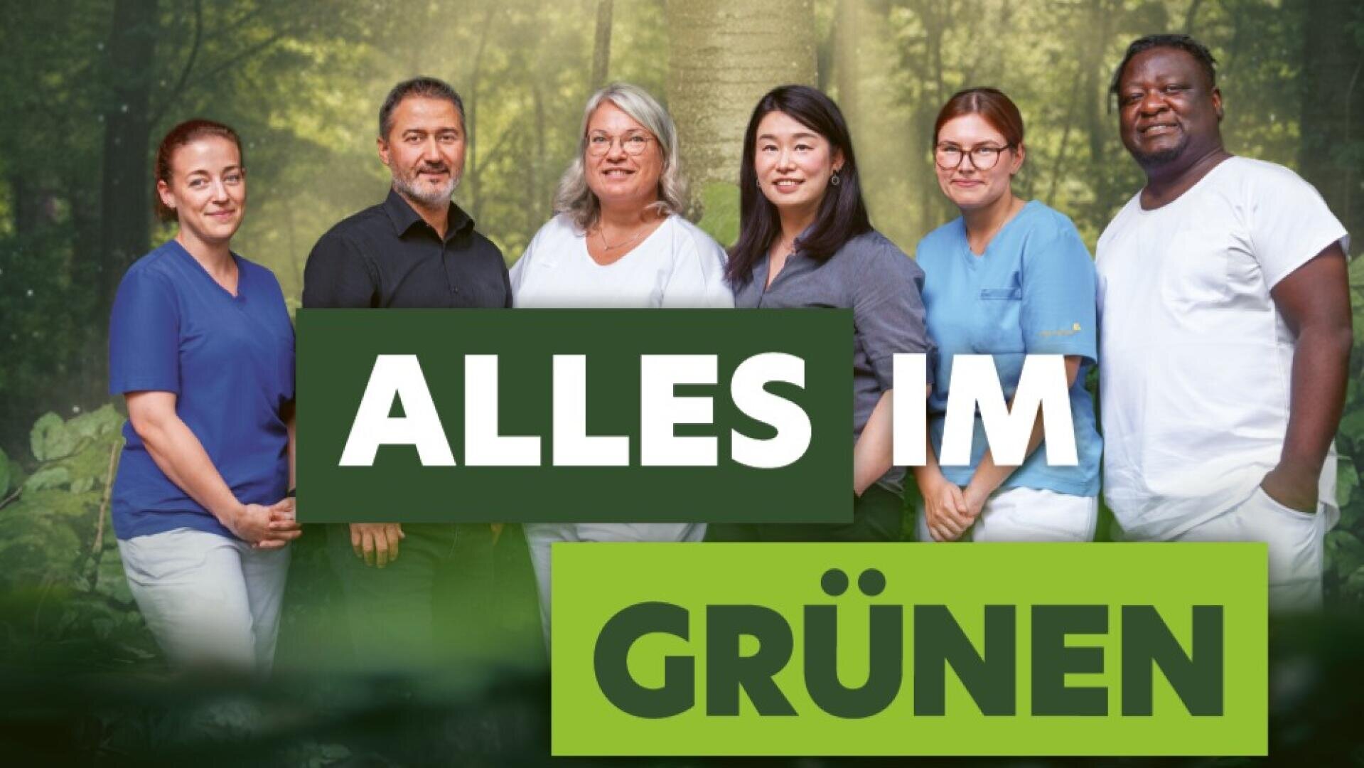 Sechs Menschen stehen lächelnd vor einem Waldhintergrund. Der deutsche Text „ALLES IM GRÜNEN“ ist in fetten grünen und weißen Buchstaben eingeblendet.