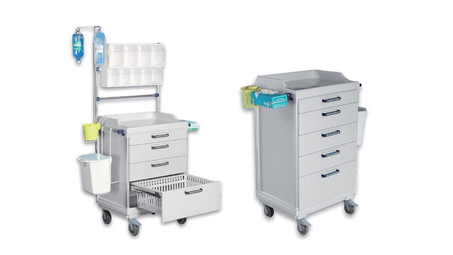 Deux chariots médicaux sur roues ; l'un avec plusieurs tiroirs, conteneurs et supports de fournitures médicales, y compris des poches à perfusion et une poubelle, et l'autre avec cinq tiroirs, une petite poubelle latérale et un plateau plat. Les deux chariots sont blancs avec des poignées bleues.